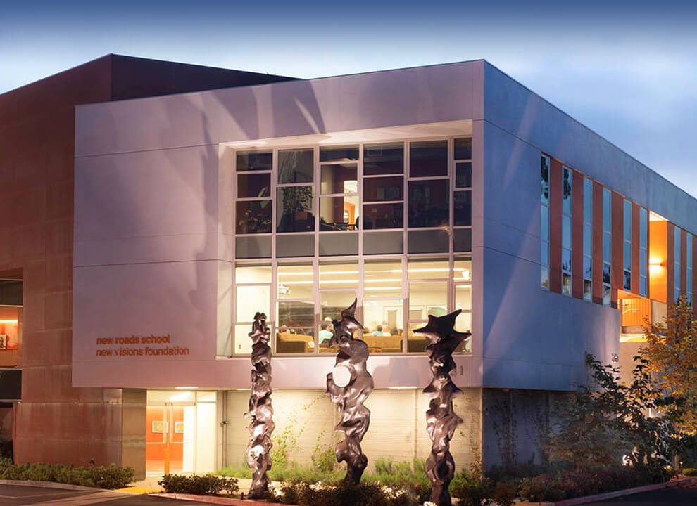 New Roads School building lit up at dusk